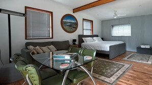 A modern bedroom with a bed, a sofa, a dining table with chairs, and a ceiling fan. - Cabin 2 - Accessibility, pet-friendly, adults only (Lowanna)