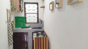 A narrow kitchen with a window, a sink, a stove, and a door.