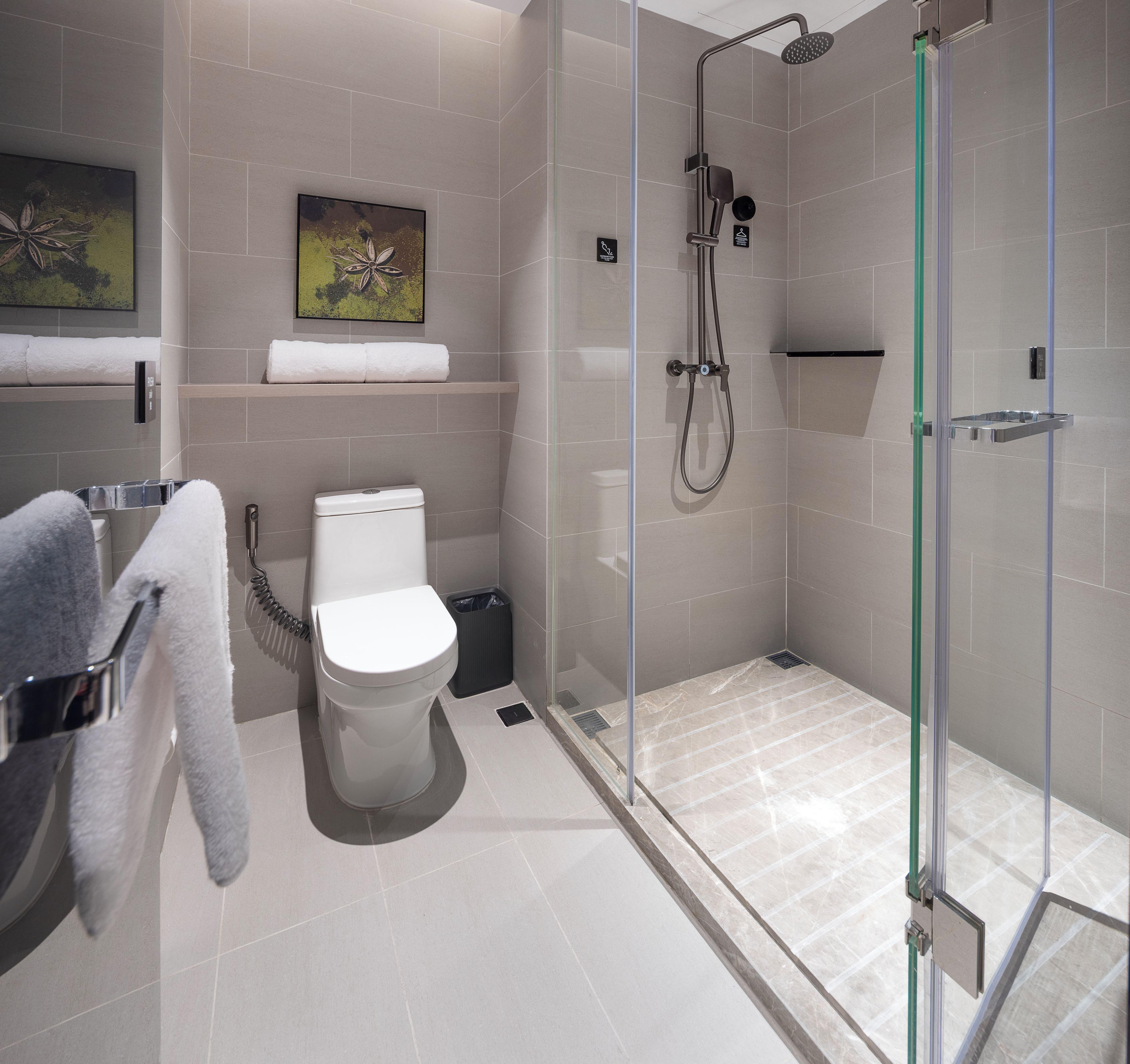 A modern bathroom with a glass-enclosed shower, a toilet, and a sink.