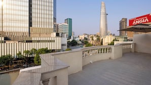A cityscape with modern buildings, a prominent tower, and a sign for 'ANGIA.' - Dream Palace Ben Thanh Grand Hotel (Ho Chi Minh City)
