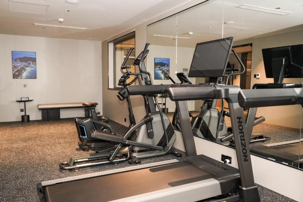 Una palestra con cyclette, tapis roulant e una panca.