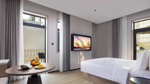 A hotel room with a bed, a dining table with breakfast, a TV on the wall, and large windows. - Dream Palace Ben Thanh Grand Hotel (Ho Chi Minh City)