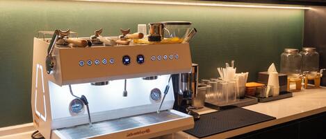 A coffee machine with digital controls, a milk frother, and a steam wand on a countertop.