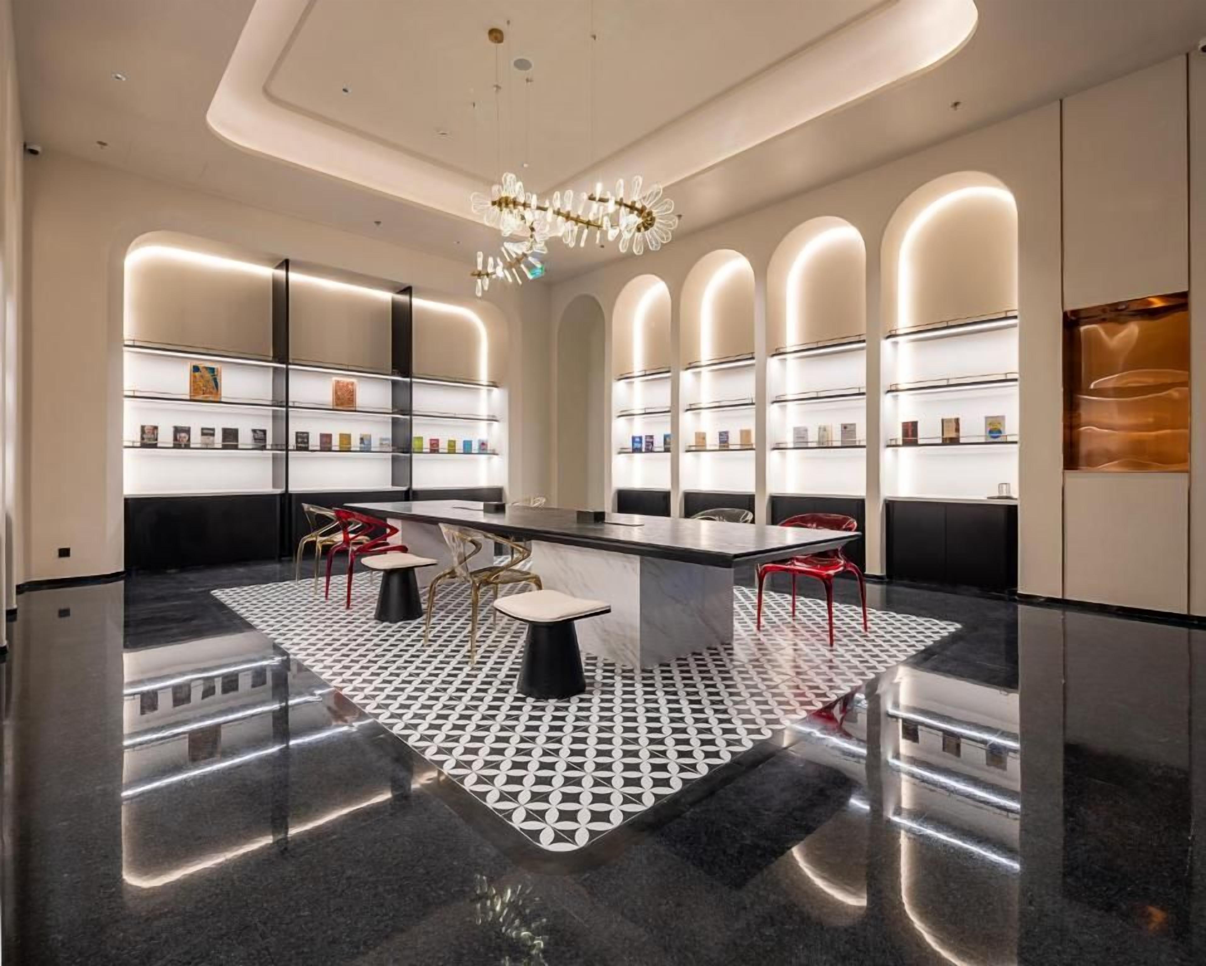 Un interior moderno con una zona de bar central, estanterías con productos y un suelo estampado.