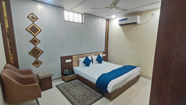Habitación de hotel con cama, una silla, mesita de noche, aire acondicionado instalado en la pared y ventana.