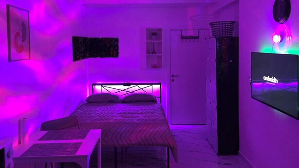 Une chambre à coucher avec un lit, un bureau, une chaise, une télévision et une porte.