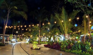 A nighttime outdoor area with palm trees, string lights, and a paved walkway. - Luxury 2BR Sanctuary Retreat Overlooking Banderas Bay (Puerto Vallarta)
