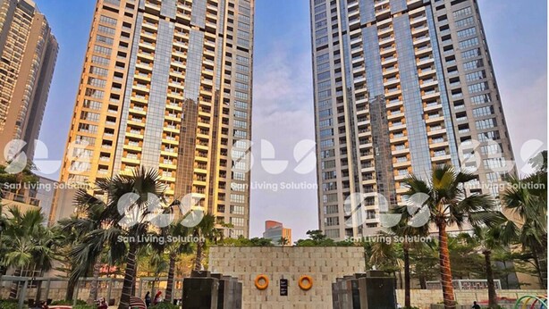 Een hoog appartementencomplex met een zwembadgedeelte op de voorgrond.