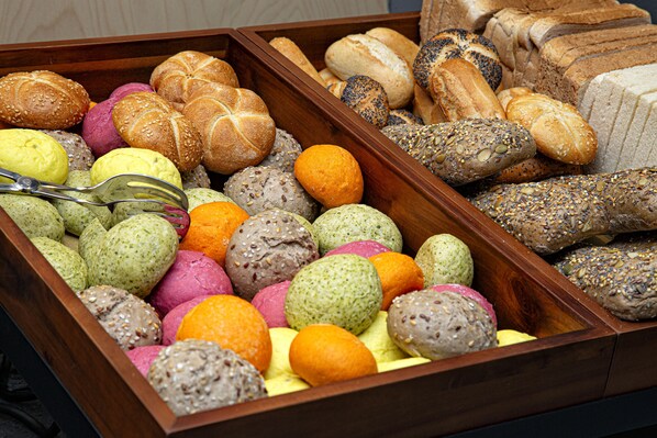 A wooden box filled with various types of bread and pastries. - Cubik Inn (Gravina di Catania)