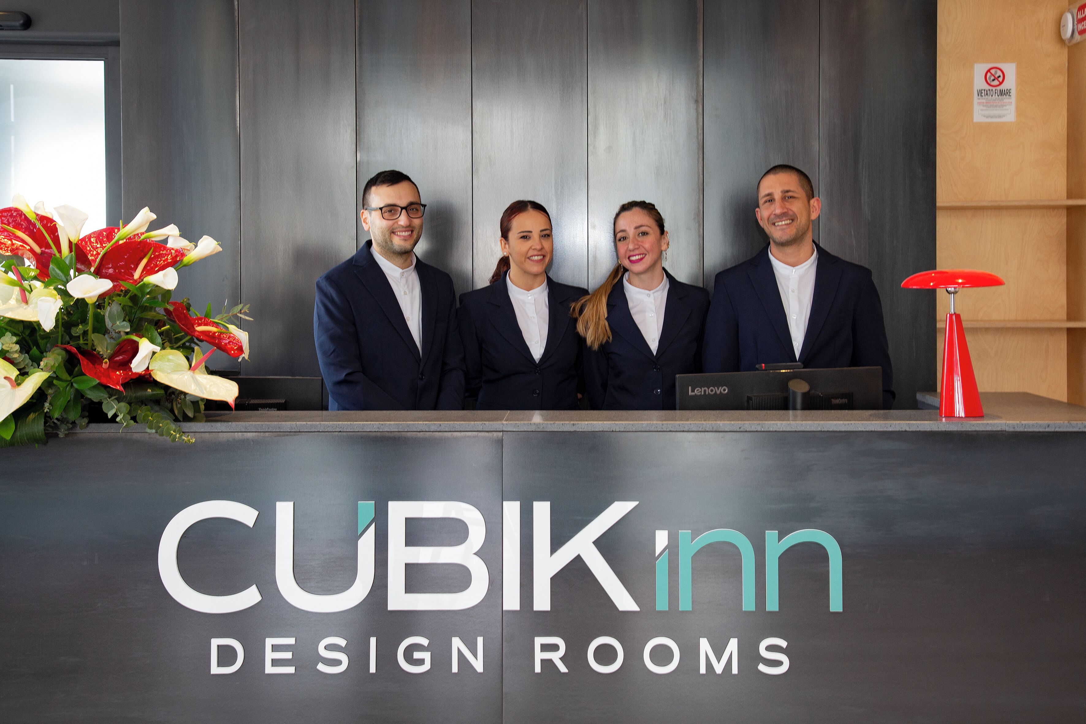 A reception desk with the text 'CUBIKinn DESIGN ROOMS' and a logo.