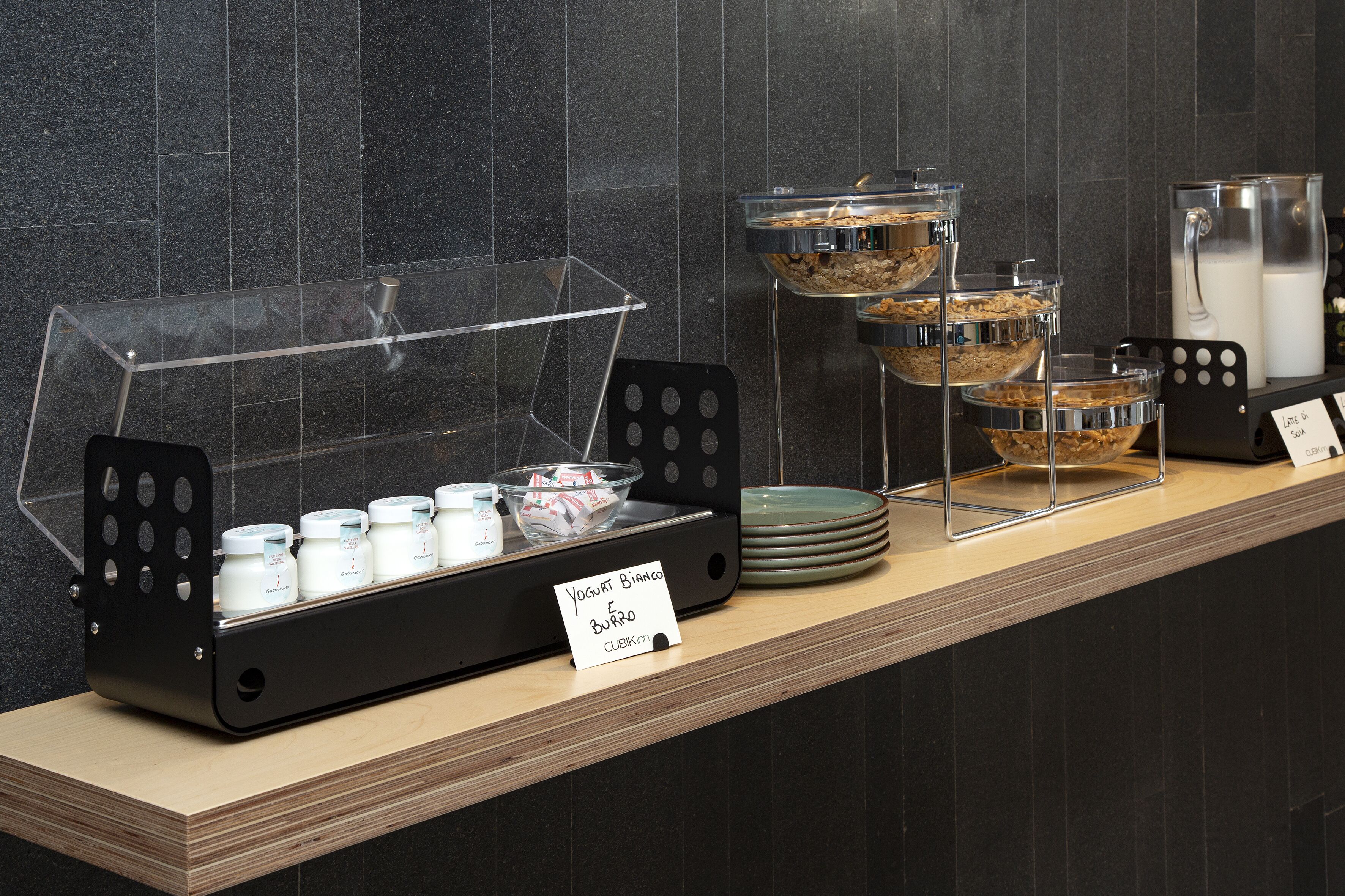 A breakfast buffet with yogurt, cereal, and milk.
