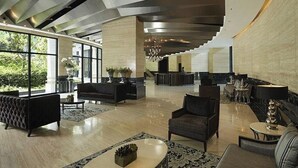 Eine geräumige Lobby mit moderner Einrichtung, großen Fenstern und einem einzigartigen Deckenstil.