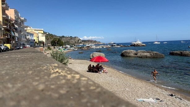 A coastal town with a pebble beach, boats, and yachts in the background. - Kyma Luxury Apartment - Sea & Taormina, Giardini Naxos, Sicily (Giardini Naxos)