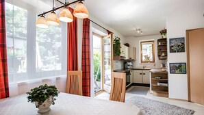 Een moderne keuken met een eethoek, grote ramen en uitzicht op de omgeving.
