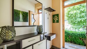 Een moderne badkamer met een grote spiegel, een wastafel en een raam met uitzicht op groen.