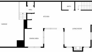 En planritning som visar ett garage, matplats, kök, hall, badrum, entré och vardagsrum.
