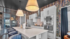 Eine moderne Küche mit Kochinsel, Barhocker und einer fliesenverzierten Spritzschutzwand.