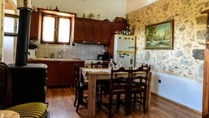 Eine rustikale Küche mit Holzschnitzschränken, einer Steinwand und einem großen Fenster.