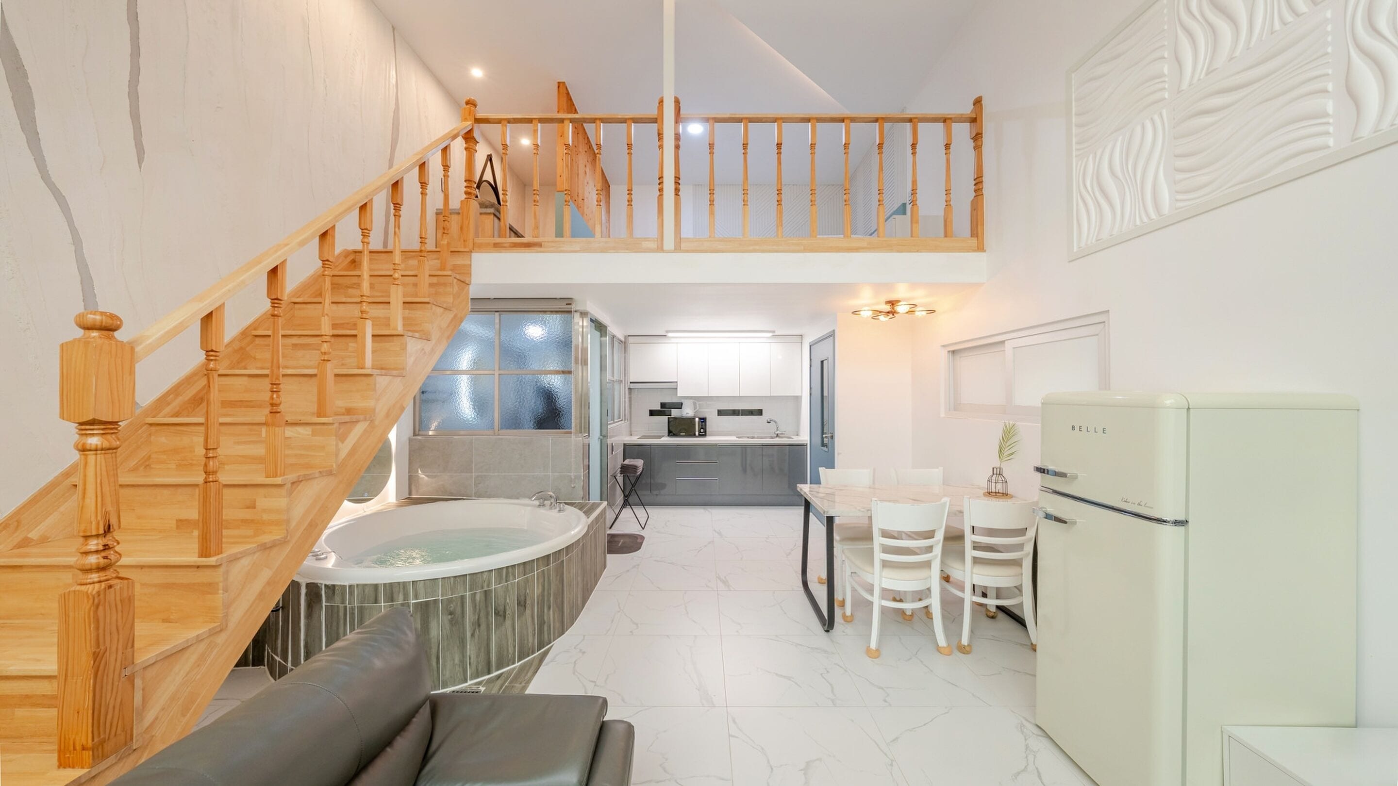 A modern interior with a wooden staircase, a kitchen, a dining area, and a living space.