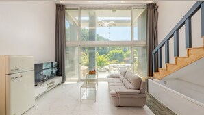 A modern living room with a sofa, a flat-screen TV, and a refrigerator. - Gapyeong Abek J Pool Villa (Gapyeong)