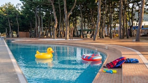 A swimming pool with a yellow inflatable duck, a red and blue inflatable ring, and a blue life jacket on the deck. - Taean Sagye Pension (Taean)