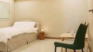 Une chambre à coucher comprenant un lit, une table de chevet, une chaise et une petite table avec deux tasses.