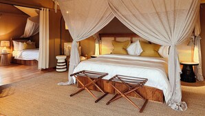 Une chambre avec un lit à baldaquin, une petite table et une chaise.
