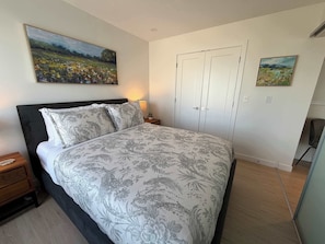 A bedroom with a bed, nightstand, and two paintings on the wall. - 1 BR in HFX with waterview, gym & 6 appliances (Halifax)