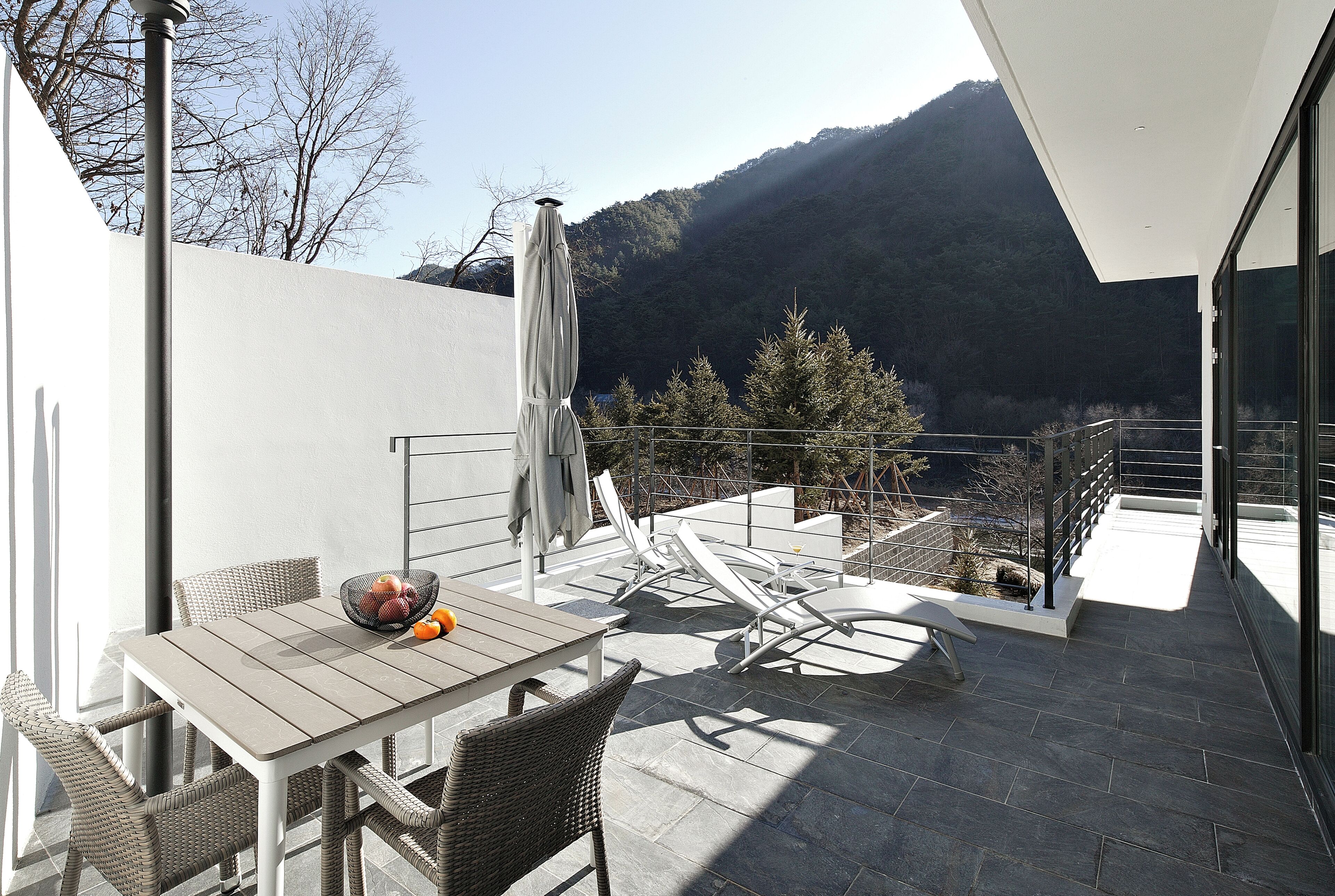 A patio with a table, chairs, and a covered umbrella.
