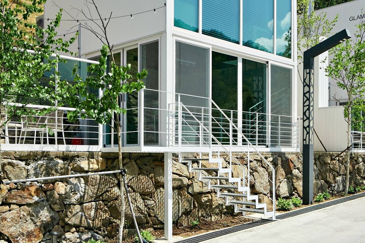 A modern building with a sign reading "GLAMPING 105".