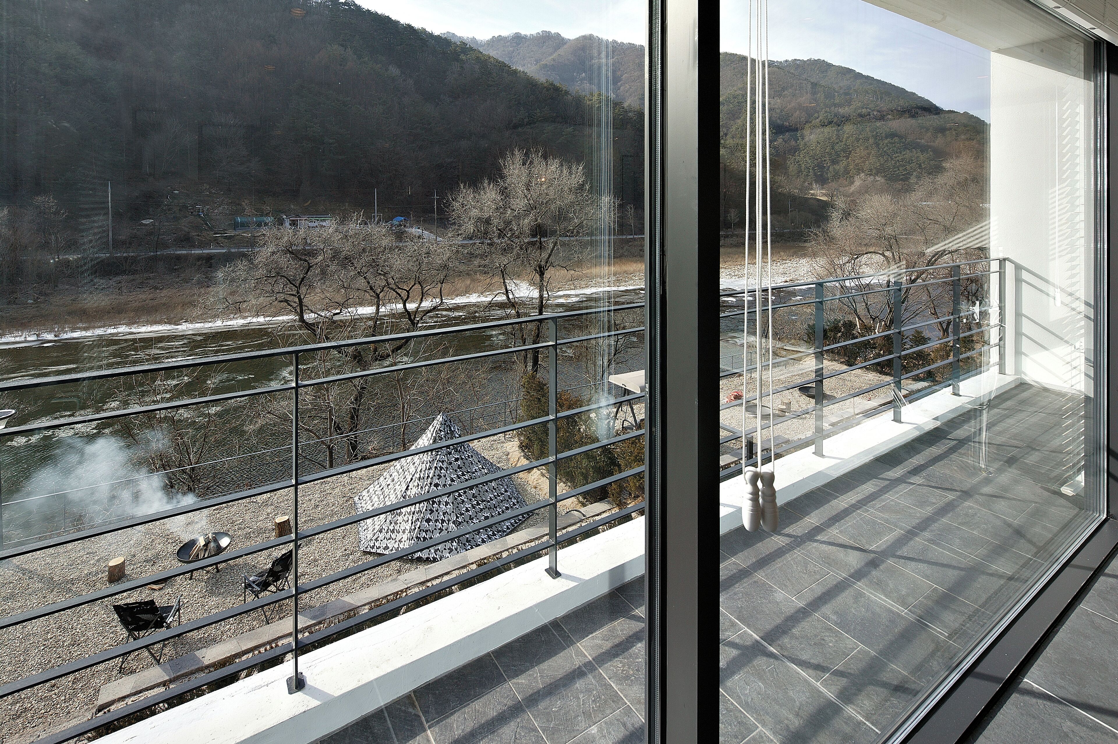 A balcony with a view of a river and mountains.