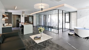Ein modernes Interieur mit Küche, Essbereich und einem gläsernen Balkon.