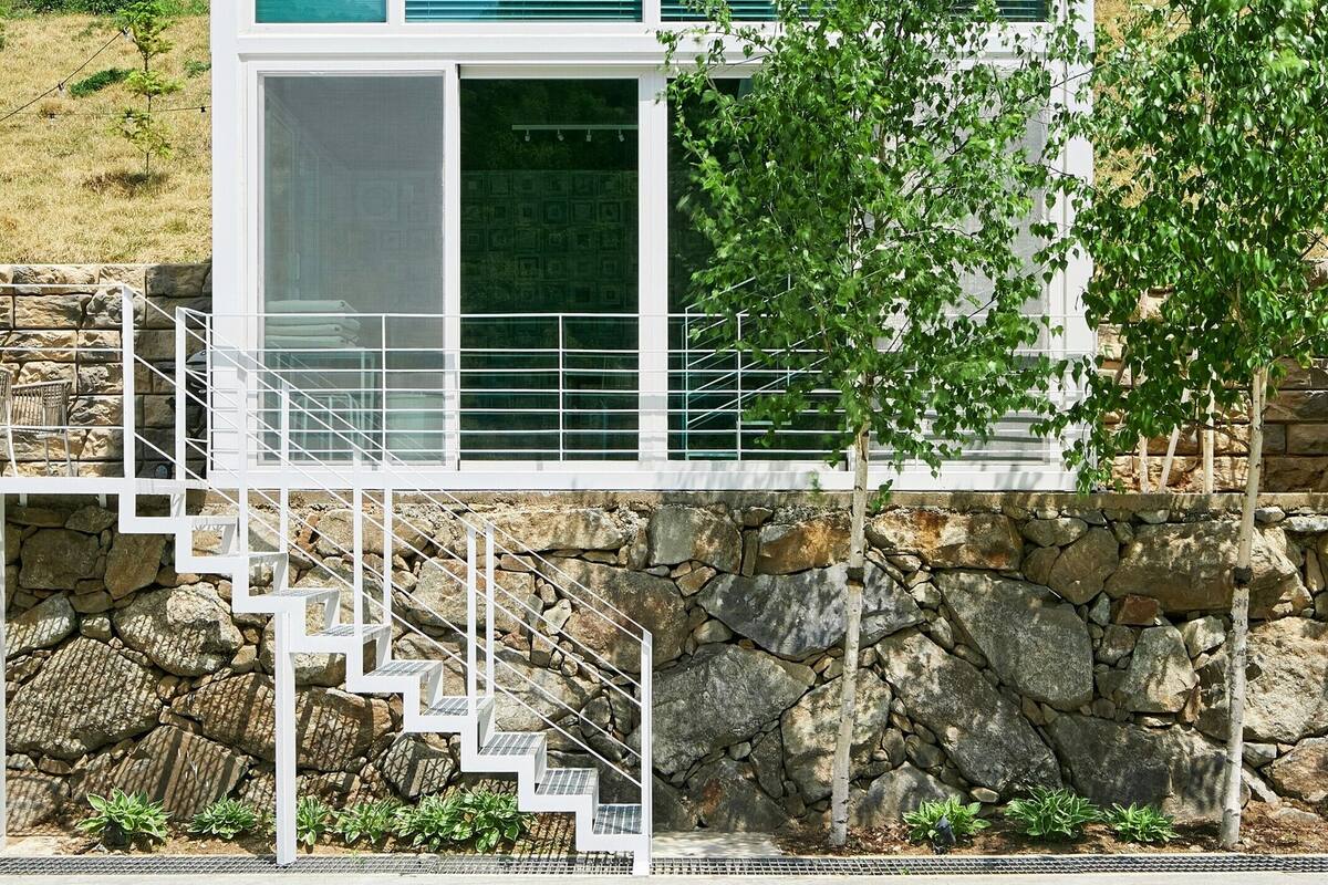 A modern building with a stone facade and a staircase leading to the entrance.
