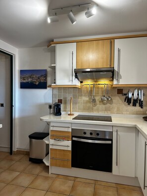 A modern kitchen with white cabinets, a stainless steel range hood, and a tiled backsplash. - La Petite Foret Sea-view Apartment in Mascarat (Altea)
