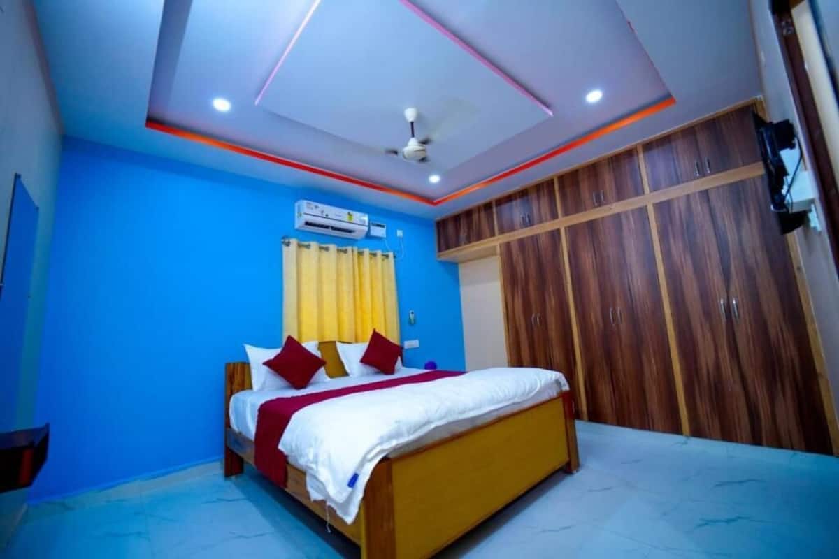 Ein Schlafzimmer mit einem Bett, einem Deckenventilator, einer Klimaanlage und Holzschränken.