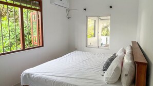 A bedroom with a bed, a window, and a ceiling fan. - Rivora 2-Bedroom Apartment in Aluthgama Near Bentota Beach (Aluthgama)