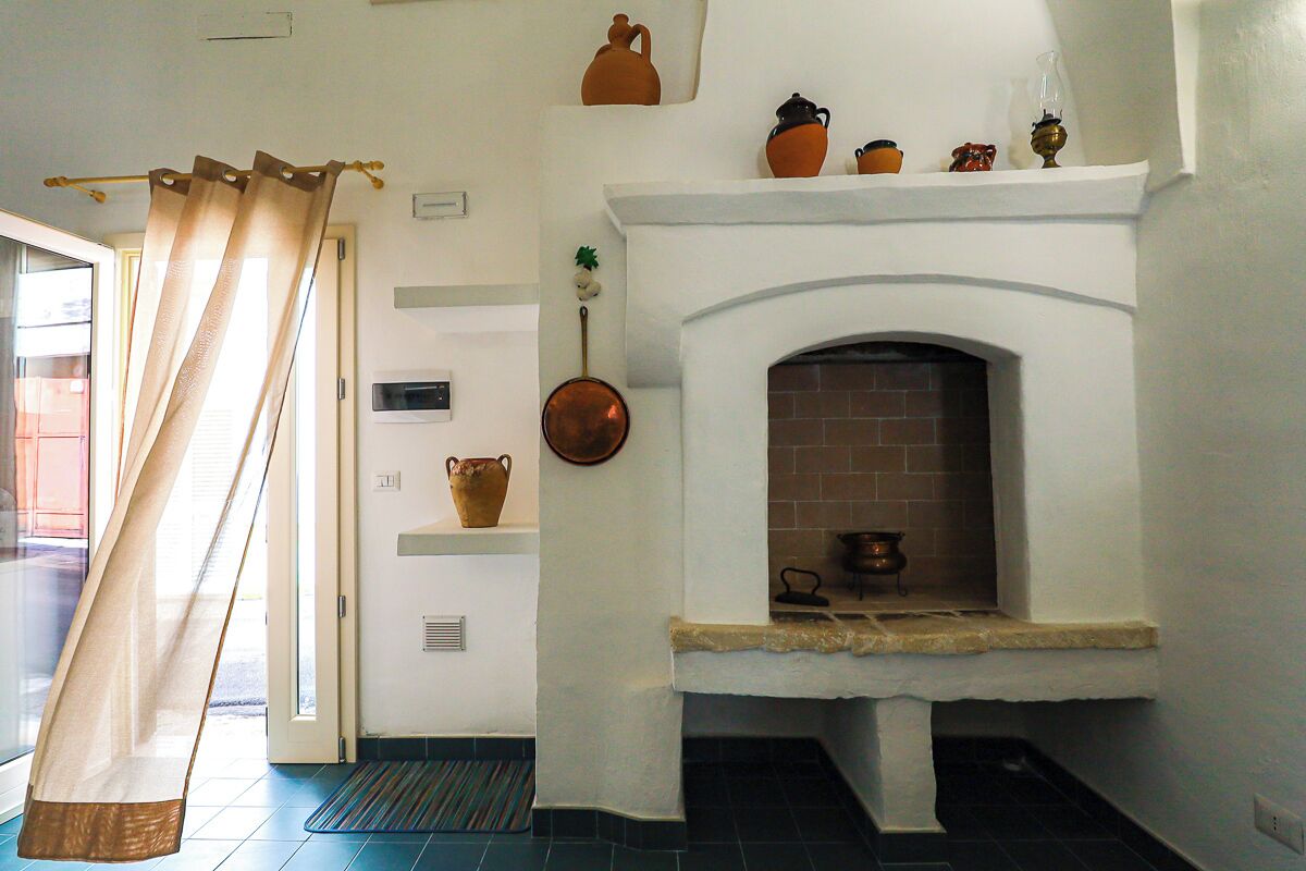 A room with a fireplace, a door with a curtain, and a tiled floor.