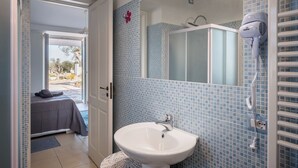 Ein Badezimmer mit Waschbecken, Spiegel und Föhn.