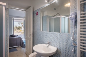 Un bagno con lavandino, specchio e asciugacapelli.