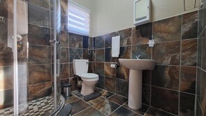 A bathroom with a shower, toilet, sink, and a mirror. - Casa de la Presa 1 (Polokwane)