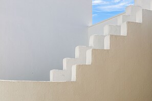 Una serie di gradini in cemento bianco che conducono ad un muro bianco.