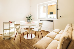 A dining area with a round table, four chairs, a plant, and a window with blinds. - Umberto I/2 by Casa di Marco (Sannicola)