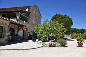 Ein Steinhaus mit einem Schild mit der Aufschrift "EPICERIE" und einer Kreidetafel, die ein Restaurant anzeigt.