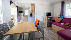 Un espace de vie compact comprenant un coin repas, une kitchenette et un coin salon.