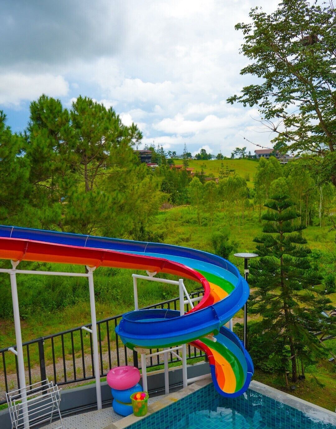 A swimming pool with a multi-colored water slide.