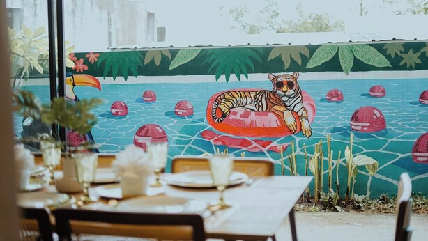 A dining area with a mural of a tiger and a pool. - Villa Verde: Relax, Unwind & Stay in Spacious Comfort (Muntinlupa)