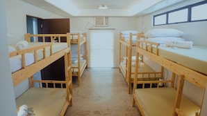 A dormitory room with bunk beds, a door, an air conditioning unit, and a window. - Villa Verde: Relax, Unwind & Stay in Spacious Comfort (Muntinlupa)