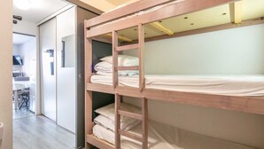 A bunk bed with a desk and chair in a room. - Charming studio apartment, sleeps 6-7, mountain view (Chamrousse)
