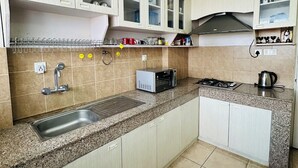 A kitchen with granite countertops, stainless steel appliances, and light-colored cabinetry. - 2-bedroom, 14th floor apartment in Nakkhu, Lalitpur nearby Medi-Citi hospital. (Lalitpur)