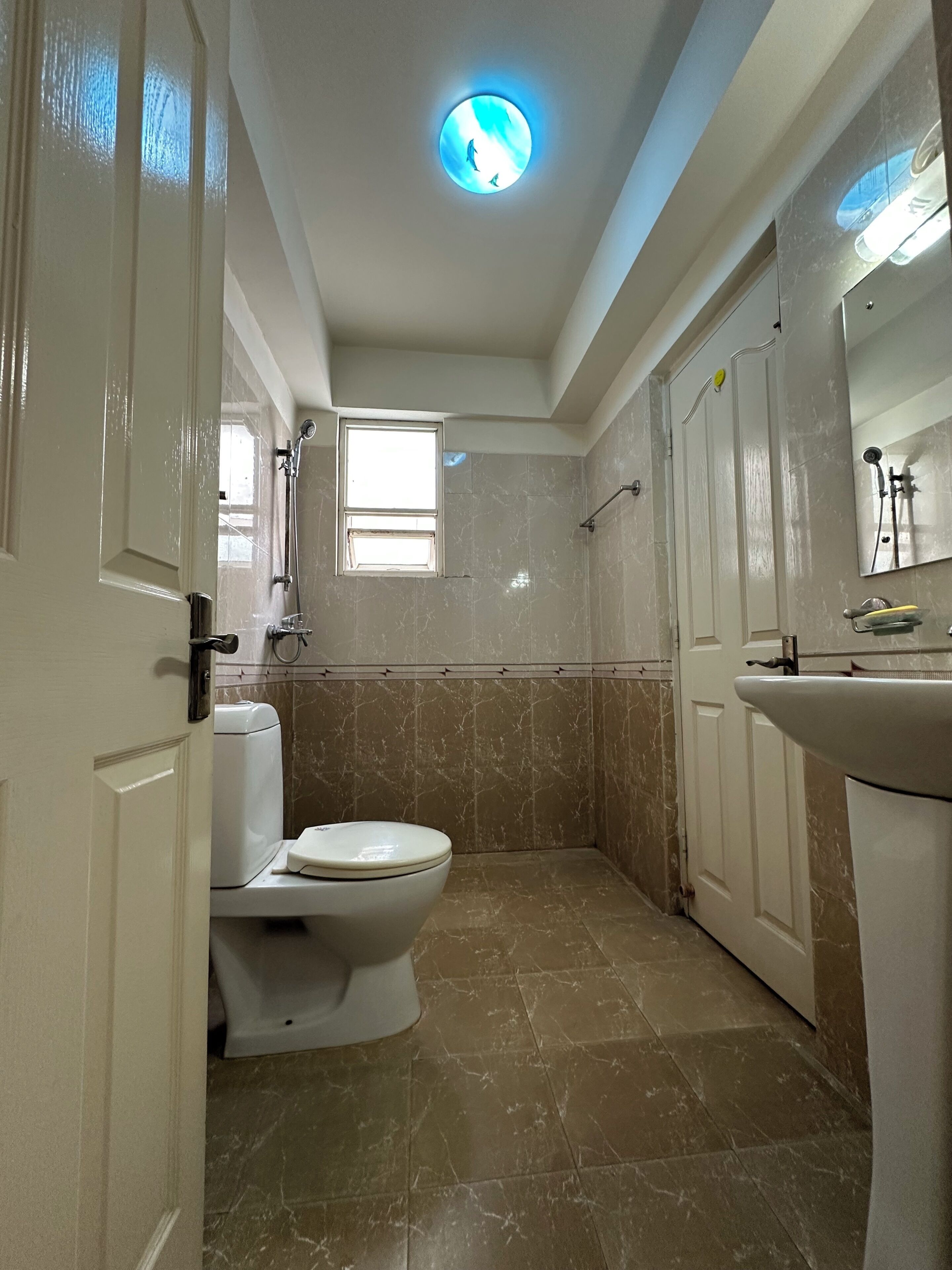 Un baño con inodoro, lavabo y ducha.